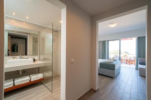 a bathroom with a sink and a bed and a mirror at Remetzo Village in Lixouri