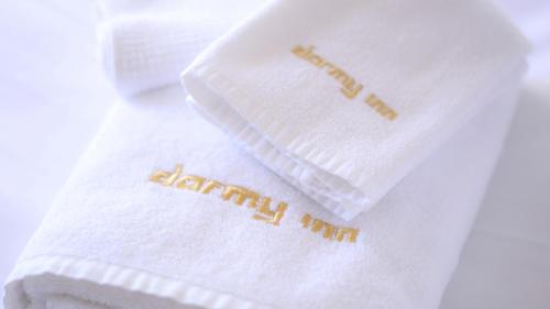 a stack of towels with the words deathmatch knit on them at Dormy Inn Kitami in Kitami