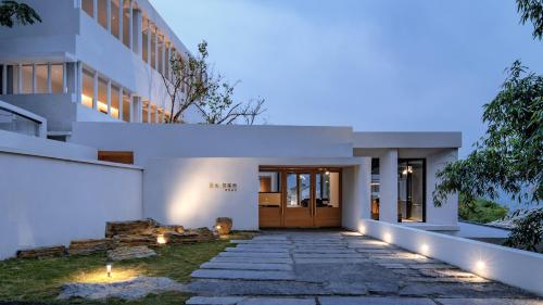 a house with a pathway leading to the front door at 至也 黄果树 in Xinggong