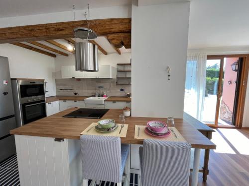 a kitchen with a wooden island with chairs in it at Incanto Chic Appartamento in Villa in Sacrofano
