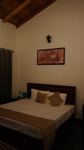 a bedroom with a large bed with white sheets at Sylvan Sunrise Homestay in Mukteswar