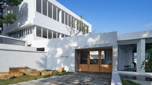 a white house with a wooden door at 至也 黄果树 in Xinggong