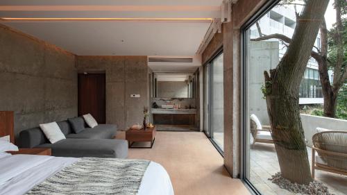a room with a bed and a couch and a window at 至也 黄果树 in Xinggong