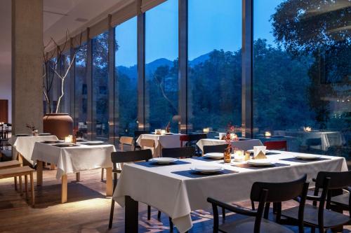 a restaurant with white tables and chairs and large windows at 至也 黄果树 in Xinggong