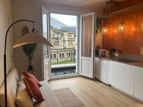 Il comprend un salon avec une cuisine et une grande fenêtre. dans l'établissement Appartement privé, vue eglise, plein centre, au Havre
