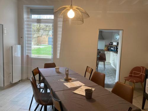 a dining room with a table and a kitchen at La marine D'opale in Ambleteuse