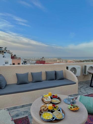 a table with plates of food on a couch at Playa Surf House in Tamraght Ouzdar