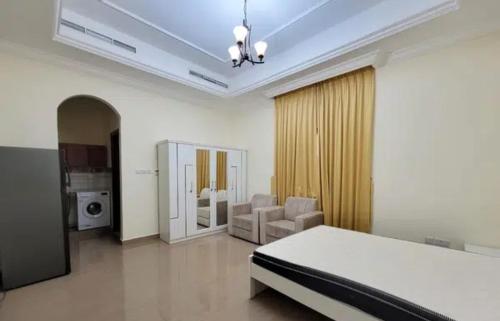 a bedroom with a bed and a living room at Apex Inn - 7 Min To Zayed Airport in Al Qurayyah