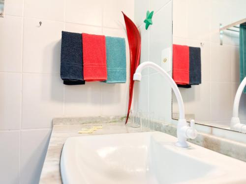 a bathroom with a sink and a mirror and towels at Pousada Casa da Edinha in Ilha de Boipeba