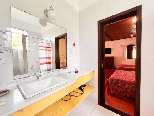 a bathroom with a sink and a bed at Pousada Casa da Edinha in Ilha de Boipeba