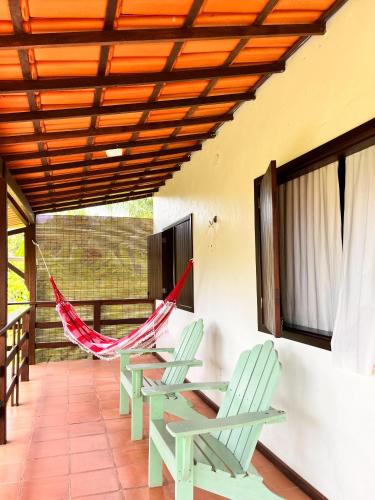 a hammock on the porch of a house at Pousada Casa da Edinha in Ilha de Boipeba