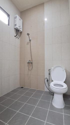 a bathroom with a white toilet and a shower at Bromo Dormitory in Bromo