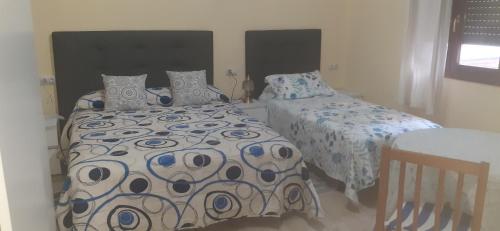 a bedroom with two beds and a table at BASAURI, céntrico, metro in Basauri