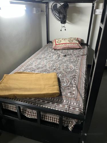 a bunk bed with a blanket and a pillow on it at Siya dormitory in Kolhapur