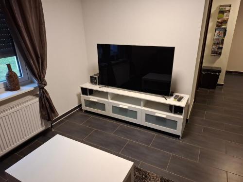 ein Flachbildfernseher auf einem weißen Entertainment-Center in der Unterkunft Casa Susanna in Wald-Michelbach