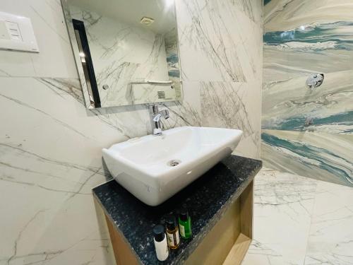 a white bathroom with a sink and a mirror at Krishna Resort Pushkar in Pushkar