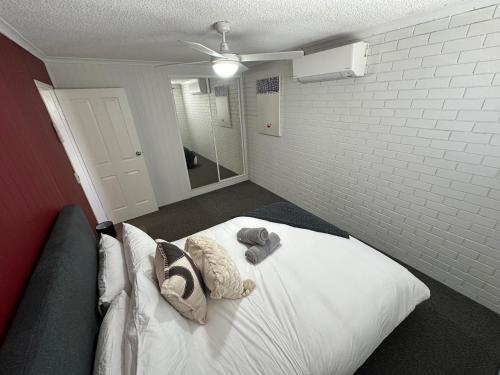 a bedroom with a bed with two pillows and a mirror at Central Cullen Wagga Apartments in Wagga Wagga
