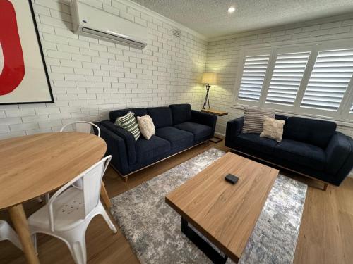 a living room with a couch and a table at Central Cullen Wagga Apartments in Wagga Wagga