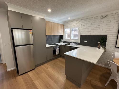 a kitchen with a refrigerator and a counter top at Central Cullen Wagga Apartments in Wagga Wagga