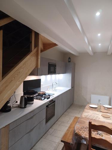 Il comprend une cuisine équipée d'une cuisinière, d'un évier et d'une table. dans l'établissement Lou Cantou des randonneurs, à Neussargues en Pinatelle