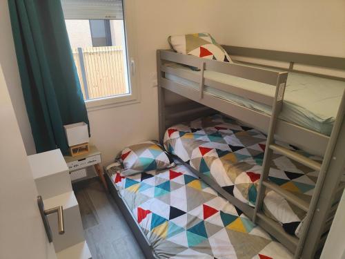 une chambre avec un lit superposé et une fenêtre dans l'établissement Maison climatisée proche Arcachon, à Gujan-Mestras