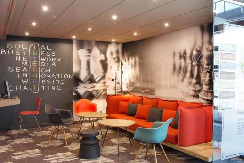a lobby with a couch and tables and chairs at Ibis Poznan Stare Miasto in Poznań
