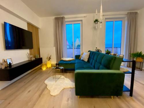 a living room with a blue couch and a tv at Cosy-Chic Apartment in Eisenach