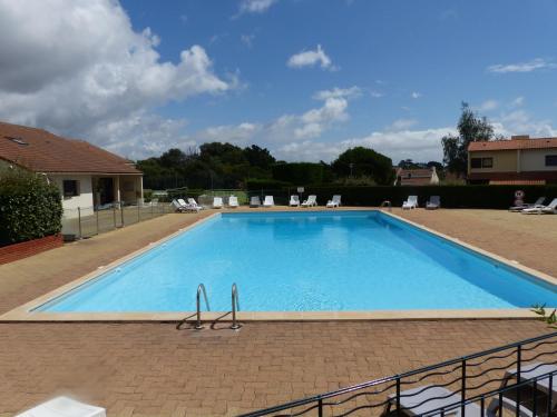 une grande piscine bleue dans une cour dans l'établissement Maison dans résidence avec piscine et tennis - 4 personnes, à Pornic