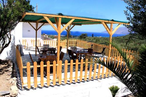 a wooden pavilion with tables and a wooden fence at Village Villa Marika Drapanias in Drapaniás