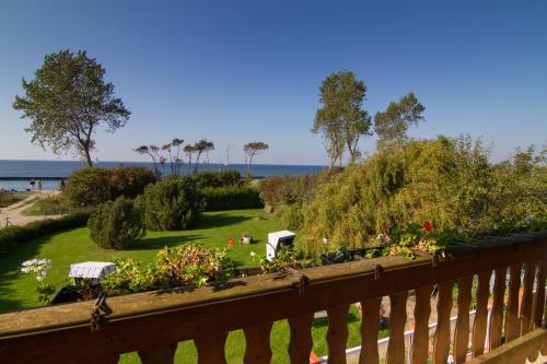 a balcony with a view of a garden and the ocean at Ferienwohnungen Dornbuschblick in Dranske