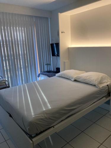a large bed in a room with a window at Strandstudio in hartje Koksijde in Koksijde