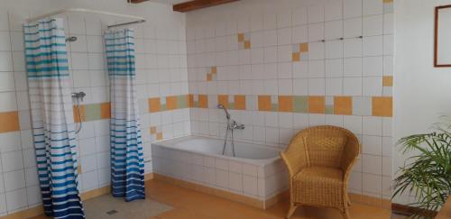 a bath tub in a bathroom with a chair at 160 qm große Ferienwohnung für 5 Personen nahe Stettiner Haff in Bugewitz