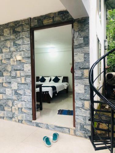 a bedroom with a mirror in a stone wall at GT COFFEE ESTATE STAY coorg in Madikeri