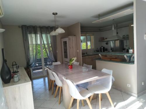 une cuisine et une salle à manger avec une table et des chaises dans l'établissement Maison avec grande piscine près de Nîmes, à Redessan