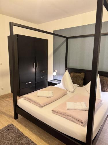 a bedroom with a black bunk bed with white sheets at Nettersheimer Hof 1857 in Nettersheim