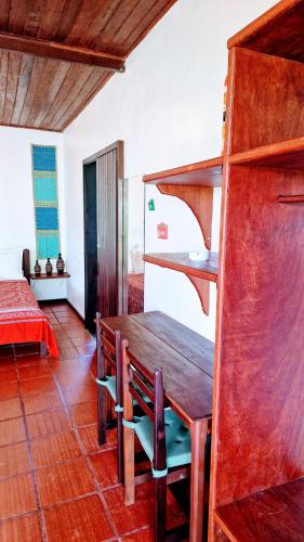 a dining room with a wooden table and chairs at Pousada Casa da Edinha in Ilha de Boipeba