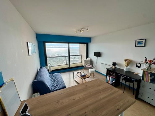 un salon avec une table et un bureau dans l'établissement Vue Mer Exceptionnelle - 2 Étoiles, à Les Sables-dʼOlonne