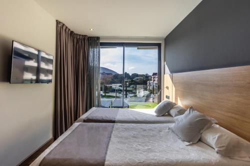 a bedroom with a large bed with a large window at Hotel Astuy in Isla