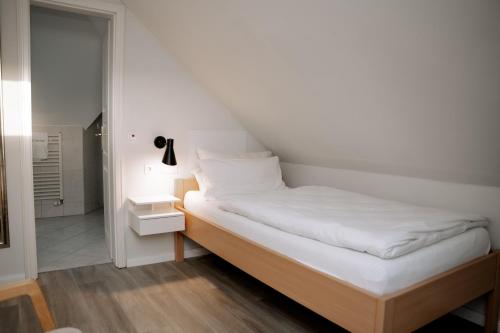 a small bedroom with a bed and a bathroom at Hotel Seehof Norderney OHG in Norderney