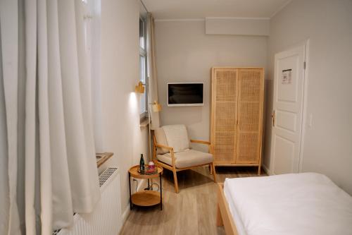 a bedroom with a bed and a chair and a television at Hotel Seehof Norderney OHG in Norderney