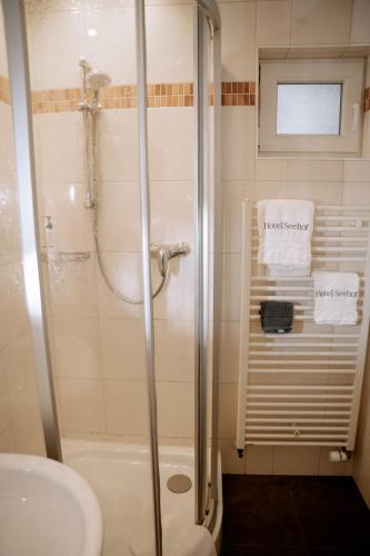 a bathroom with a shower and a toilet and a sink at Hotel Seehof Norderney OHG in Norderney