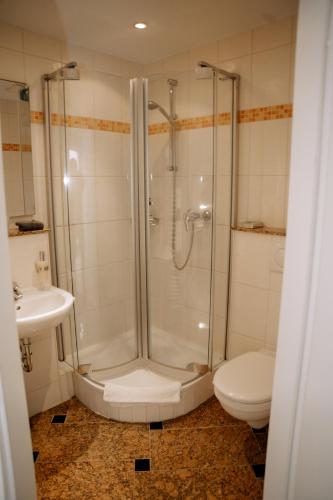 a bathroom with a shower and a toilet and a sink at Hotel Seehof Norderney OHG in Norderney