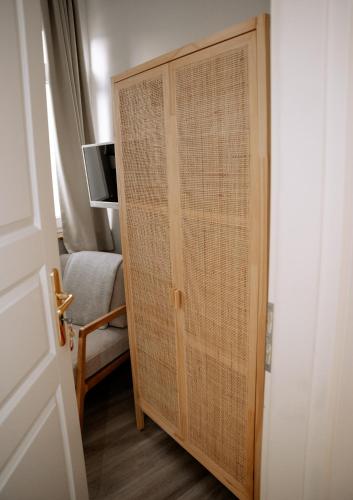 ajar door of a room with a chair and a television at Hotel Seehof Norderney OHG in Norderney