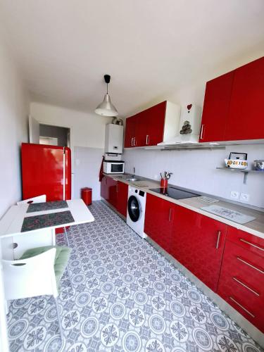 - une cuisine avec des placards rouges et une table dans l'établissement Hendaye a 6mn a pied de la plage parking privé, à Hendaye