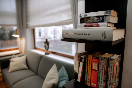 a book shelf filled with books next to a couch at Hotel Seehof Norderney OHG in Norderney