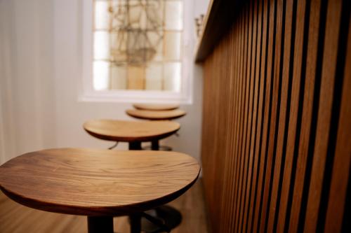 three wooden stools in a room with a window at Hotel Seehof Norderney OHG in Norderney