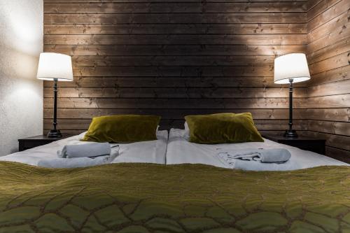 een slaapkamer met een groot bed met twee lampen bij RukaValley Unique46 Ski In - Ski Out in Ruka