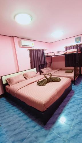 two beds in a room with pink walls at บ้านปรินรดา poolvilla สัตหีบ in Sattahip