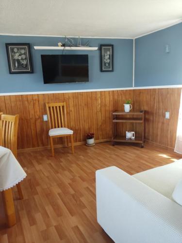 un salon avec un lit et une télévision dans l'établissement Cabaña en Hostal, El Quisco, à El Quisco