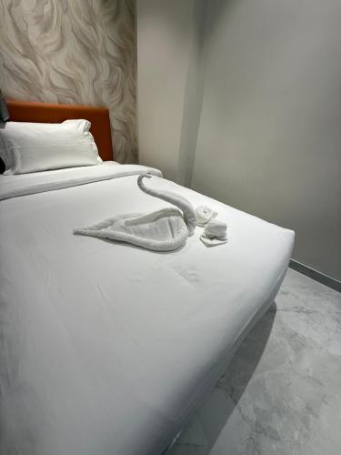 a white bed with a pair of slippers on it at Hotel Aishwarya in Akalkot